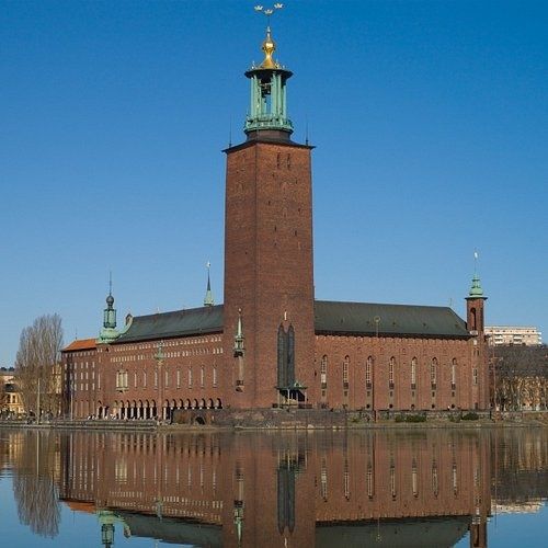 Stockholms stadshus vid vattnet, med torn och spegling i klart väder